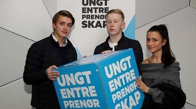 Tre elever som holder en stor kube med logo ungt entreprenørskap - Klikk for stort bilde